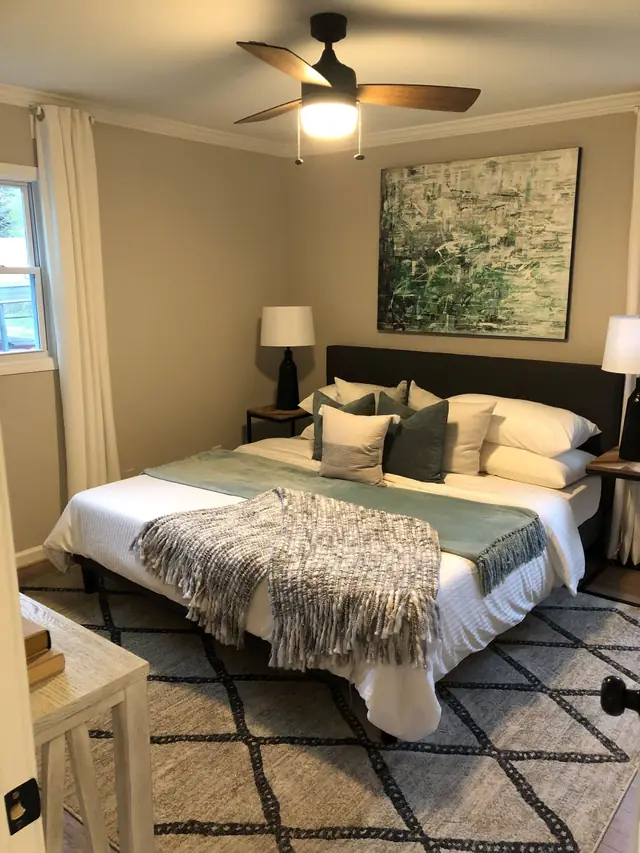 Bedroom with layered bedding and a window seat