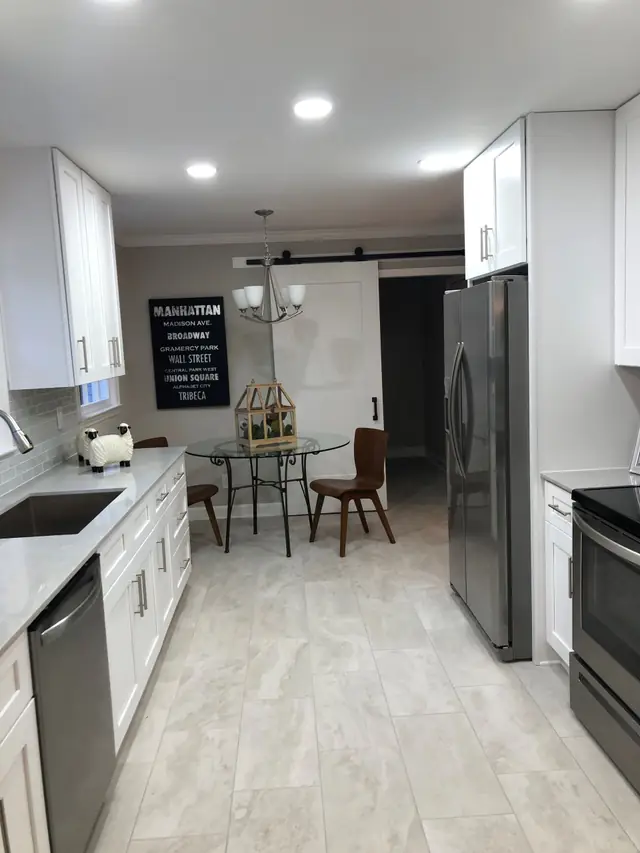 Galley kitchen with a tile floor and a barn door at the end
