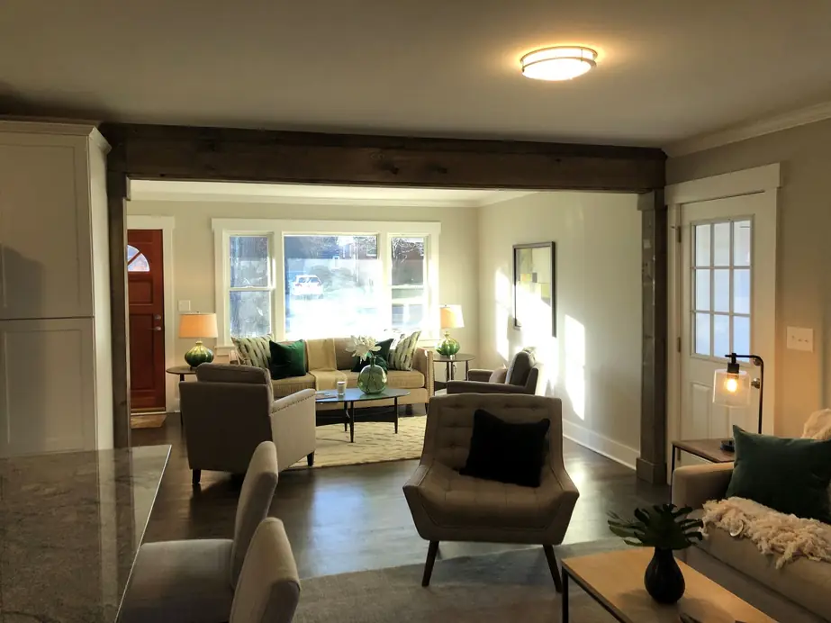 Living room seen through a wood beam toward the front door