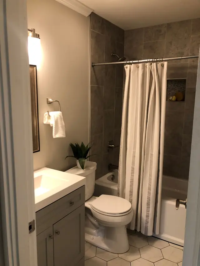 Bathroom with hexagon floor tile and a patterned shower curtain