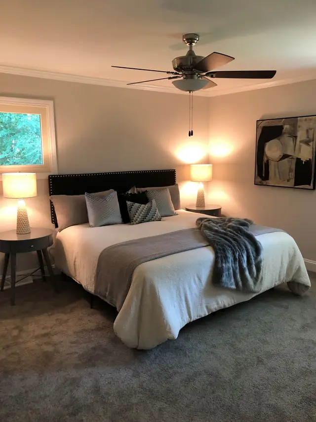 Bedroom with grey bedding and warm lamps
